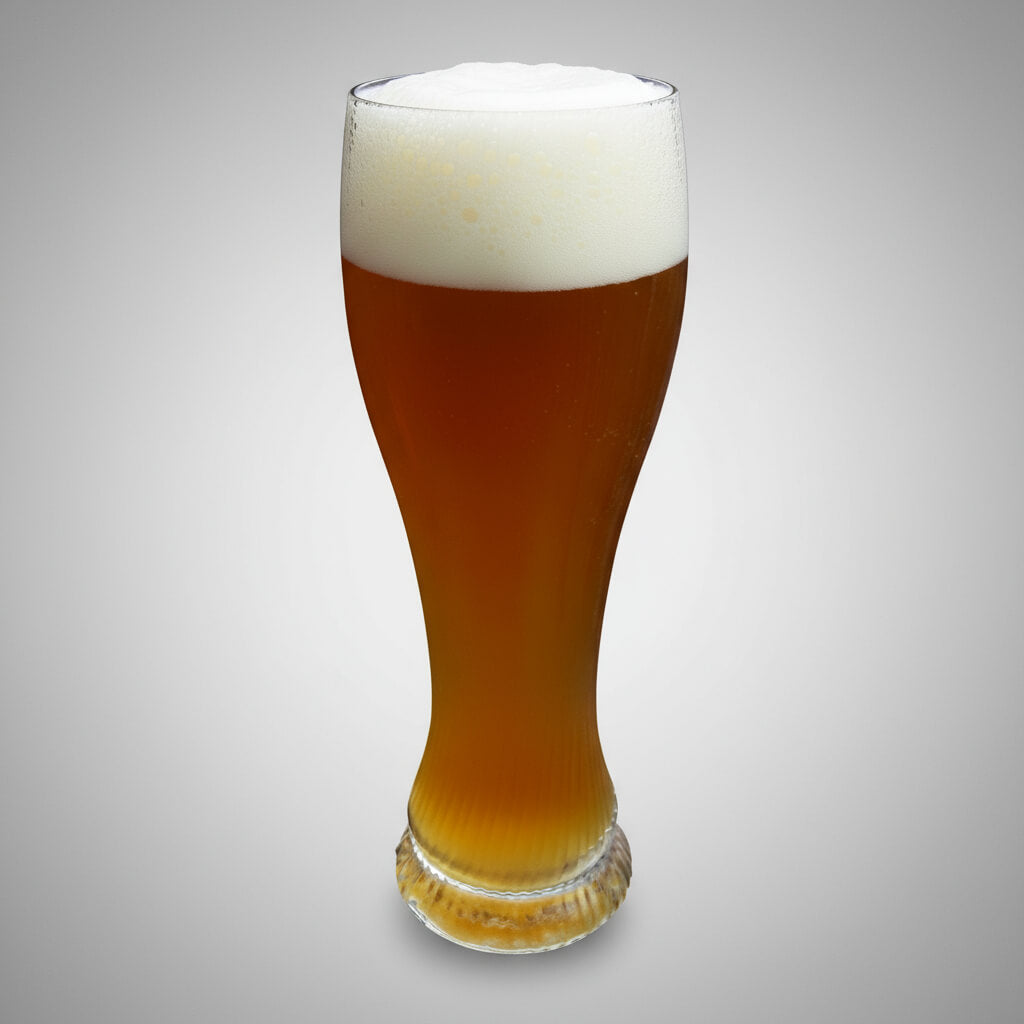 Glass of beer with a white head on a gray background