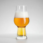 Clear glass filled with beer on a gray background